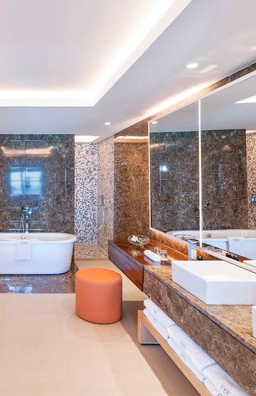 a bathroom with a tub and a large mirror