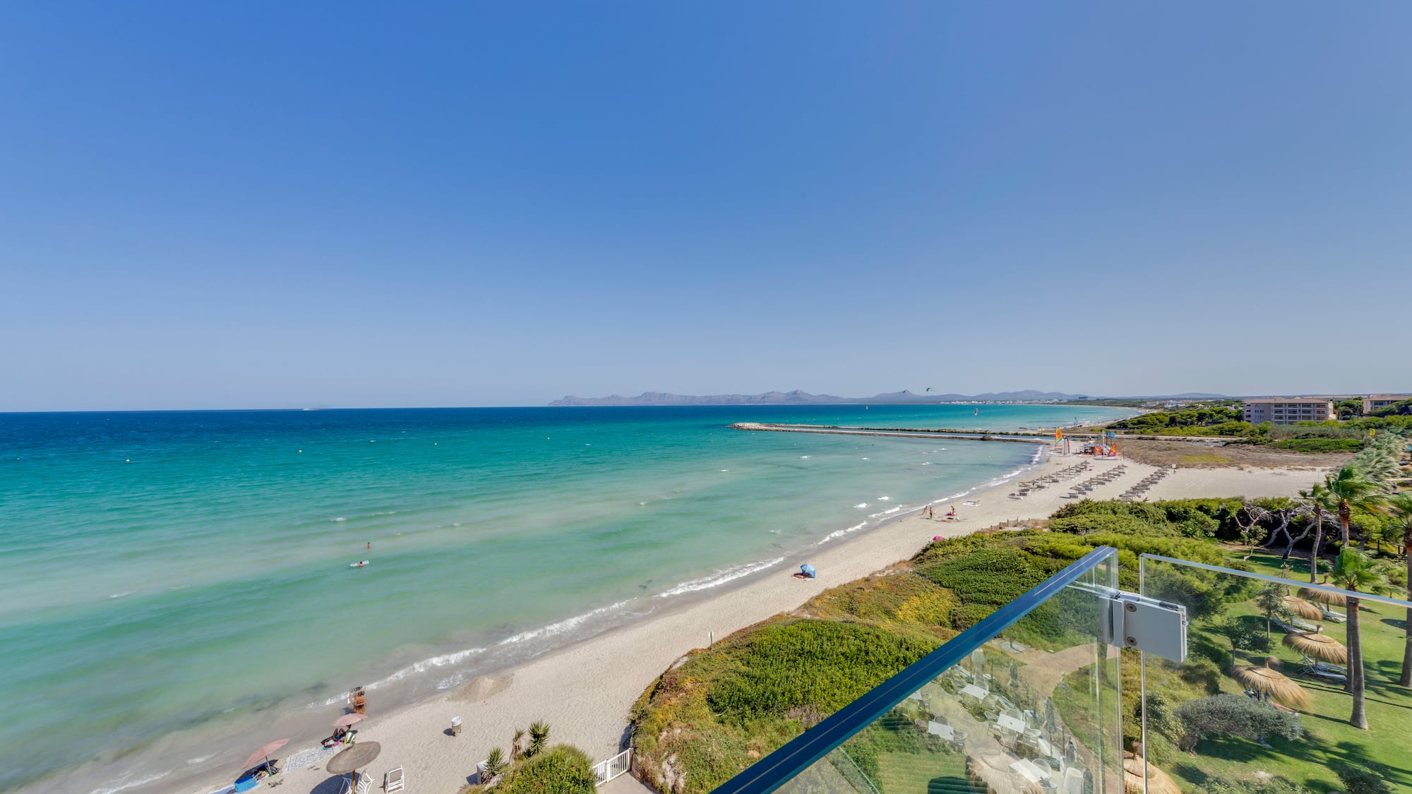 a beach with a clear blue water and a clear sky