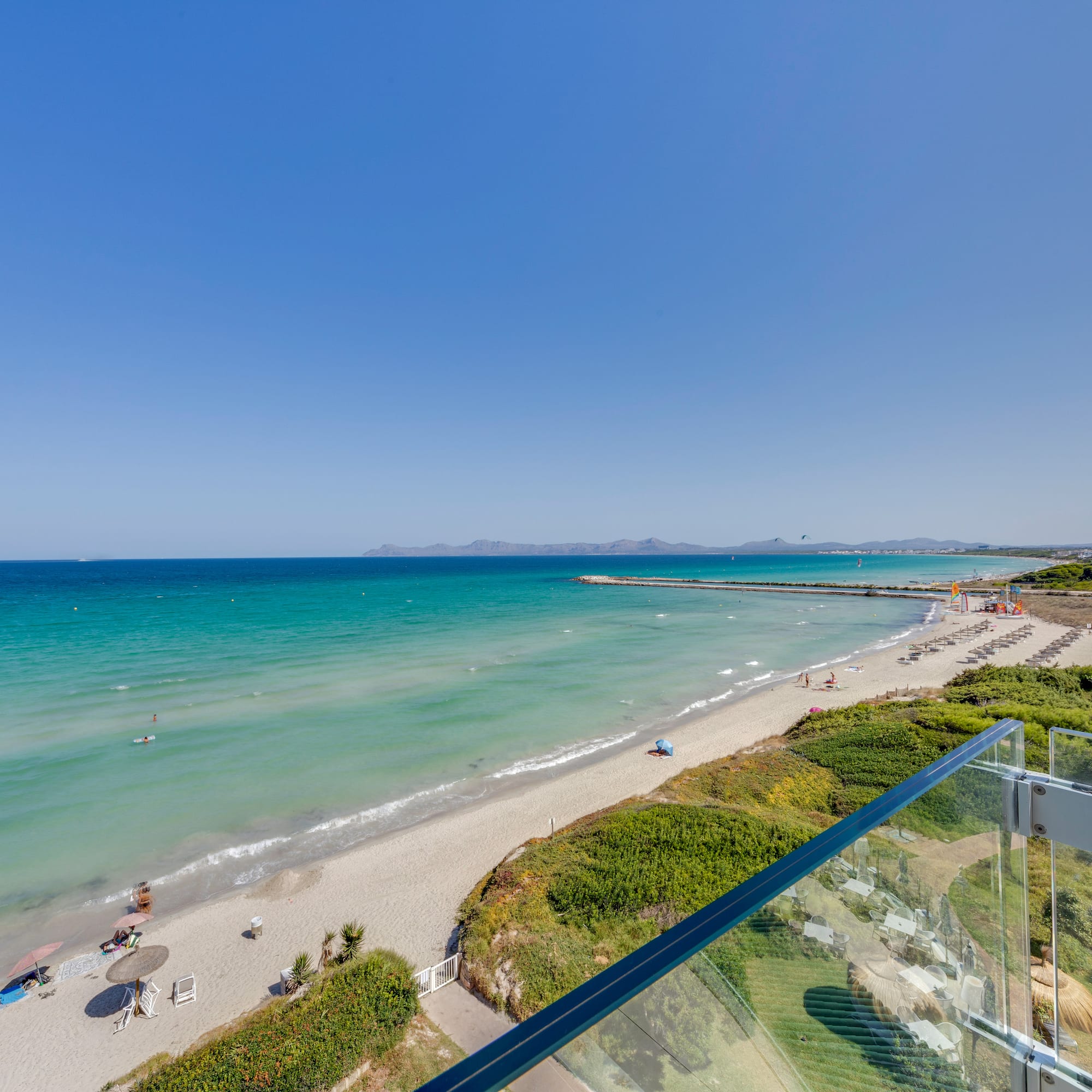 a beach with a clear blue water and a clear sky