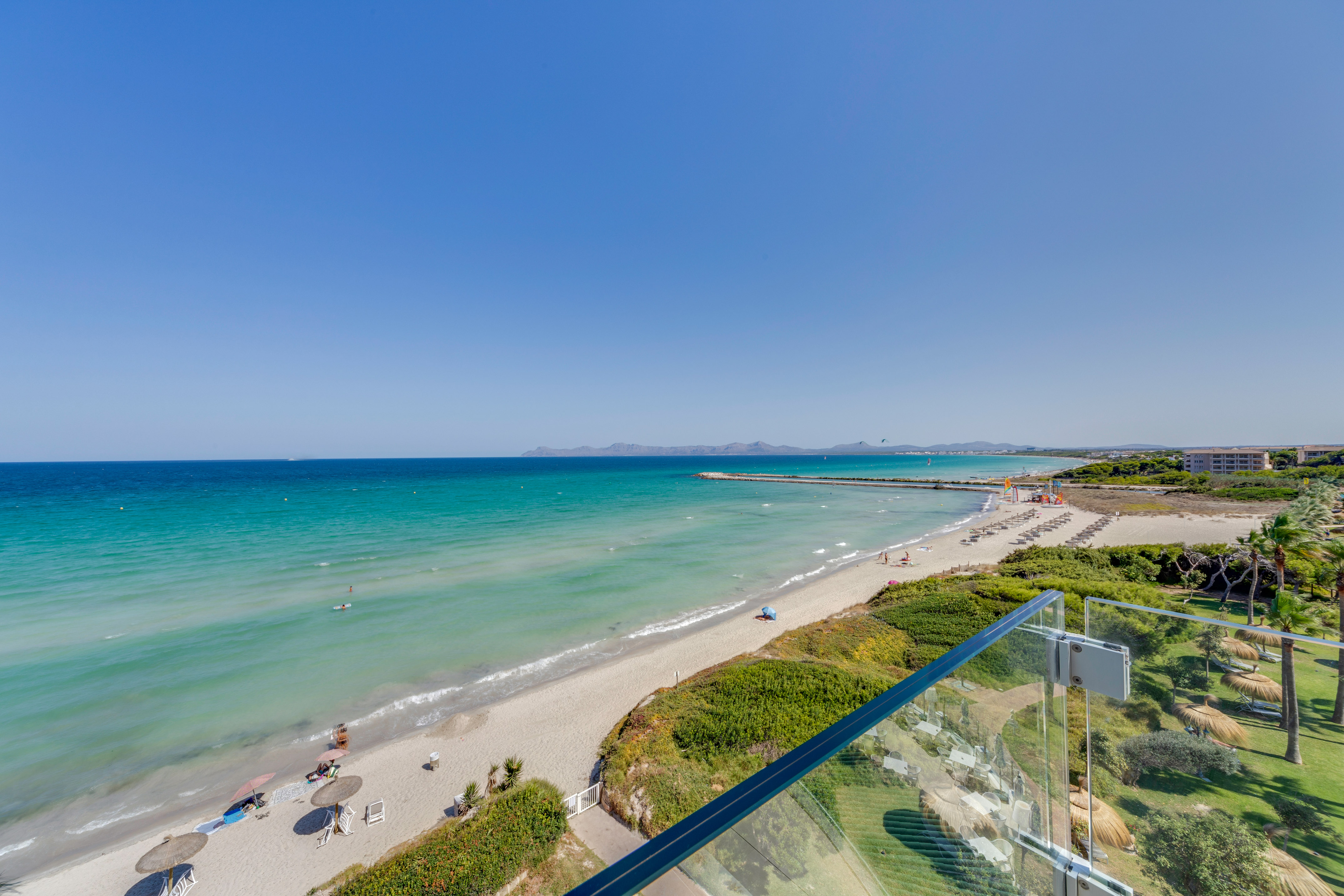 a beach with a clear blue water and a clear sky