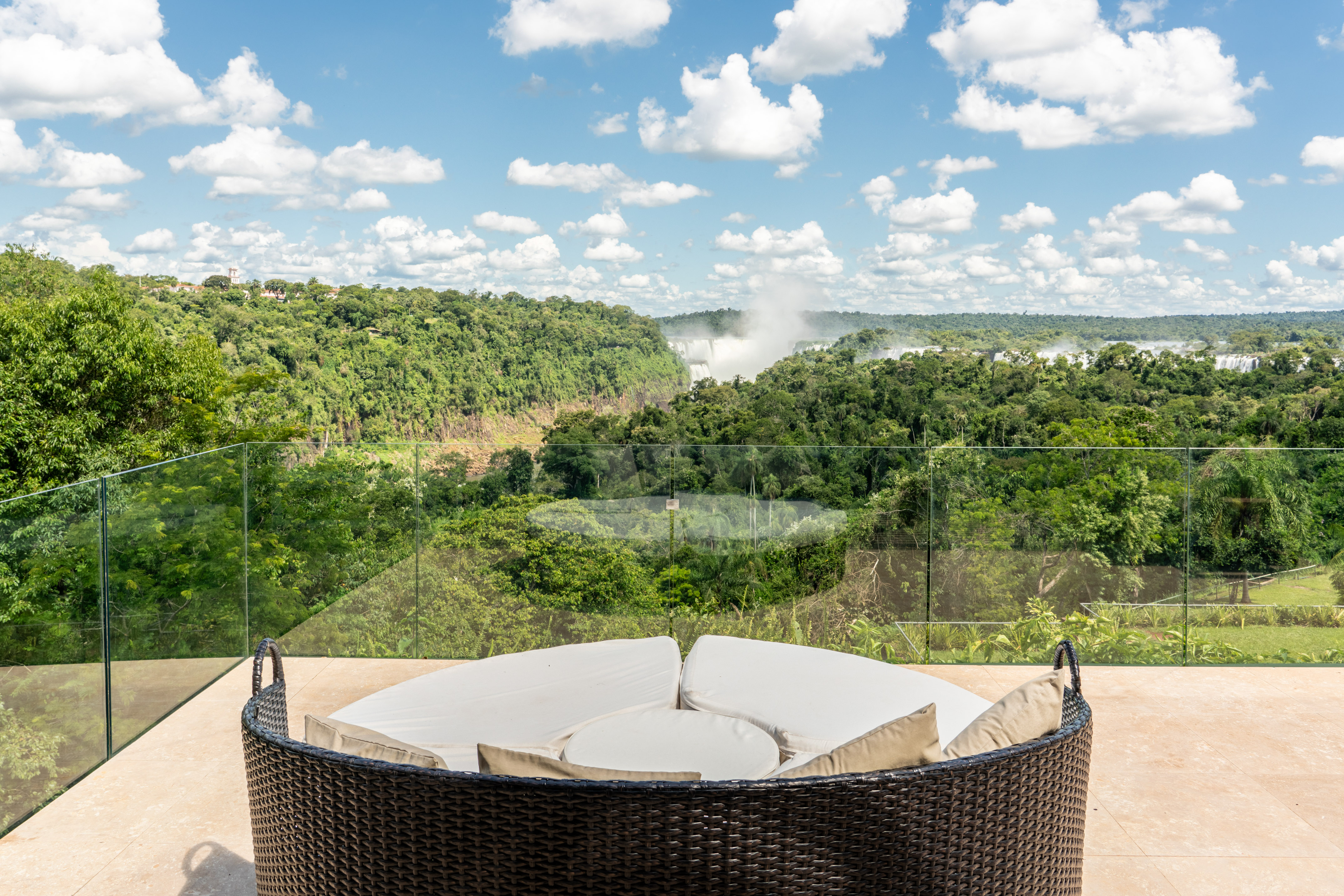 Rattan patio sofa with stunning Iguazu Falls and rainforest vista.