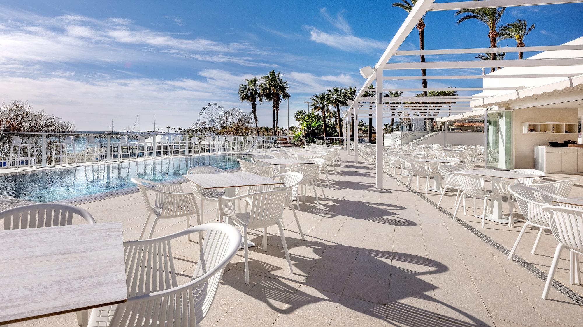 uma piscina com mesas e cadeiras