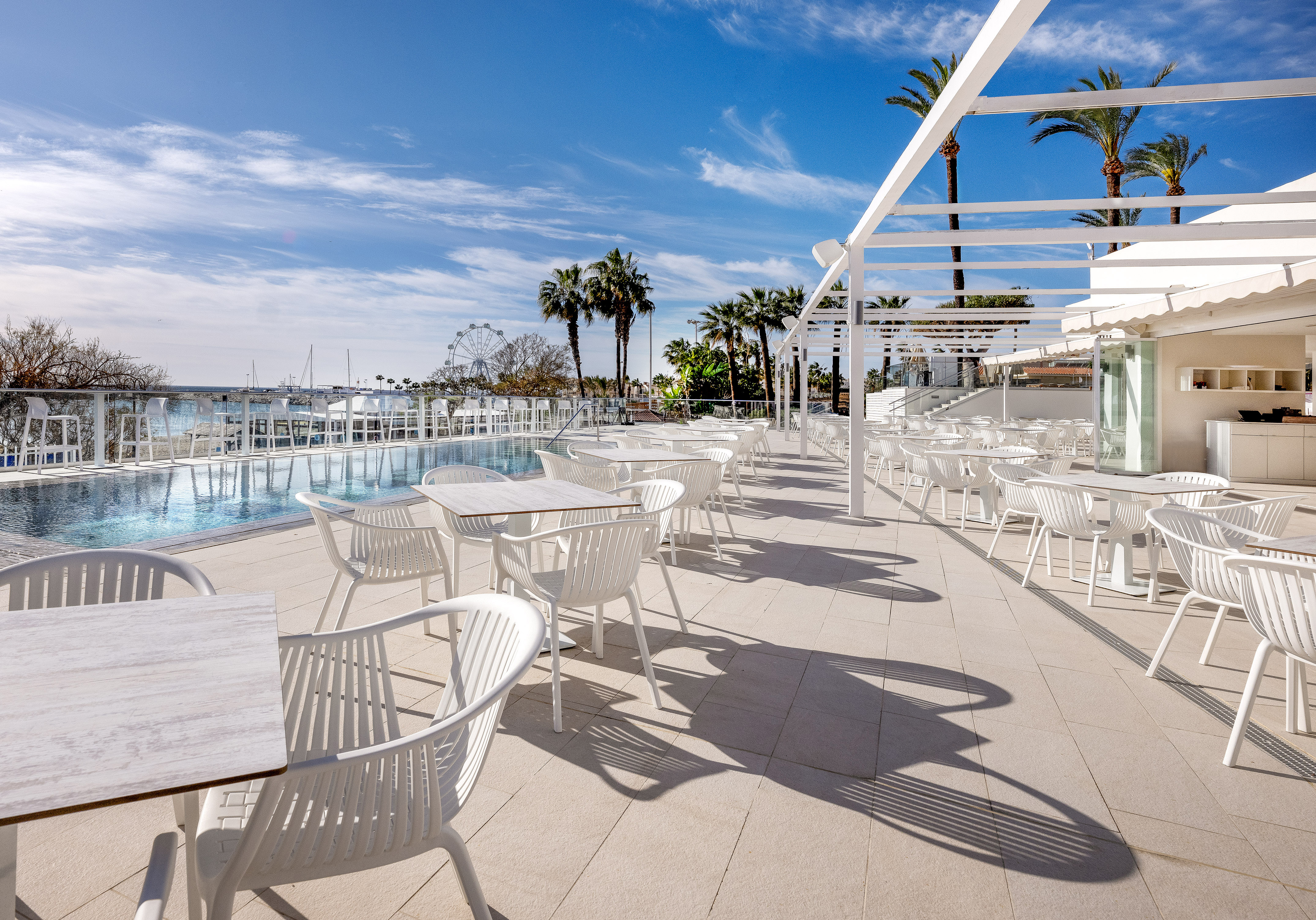 een zwembad met tafels en stoelen