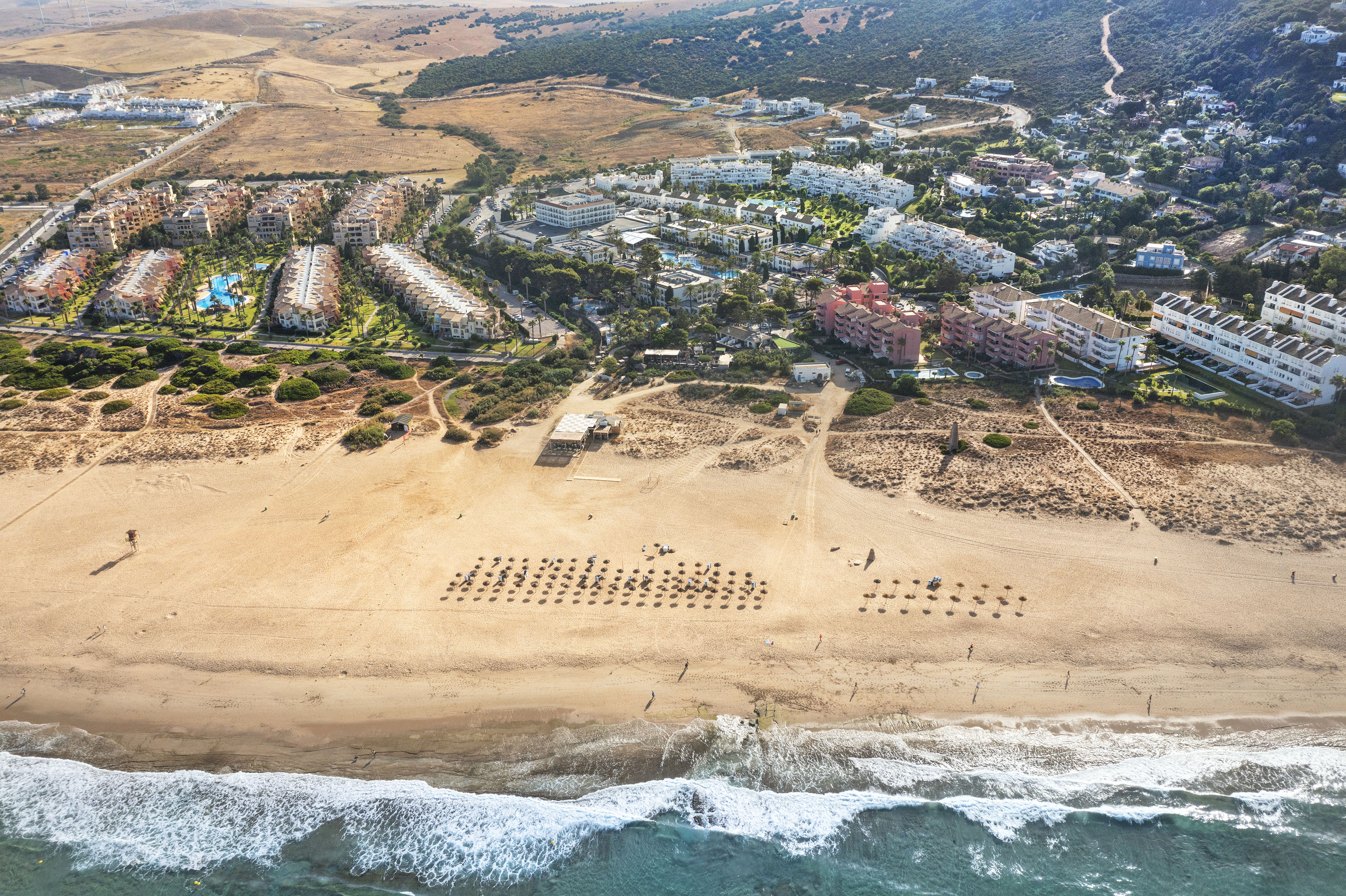 an aerial view of a beach with buildings and a body of water