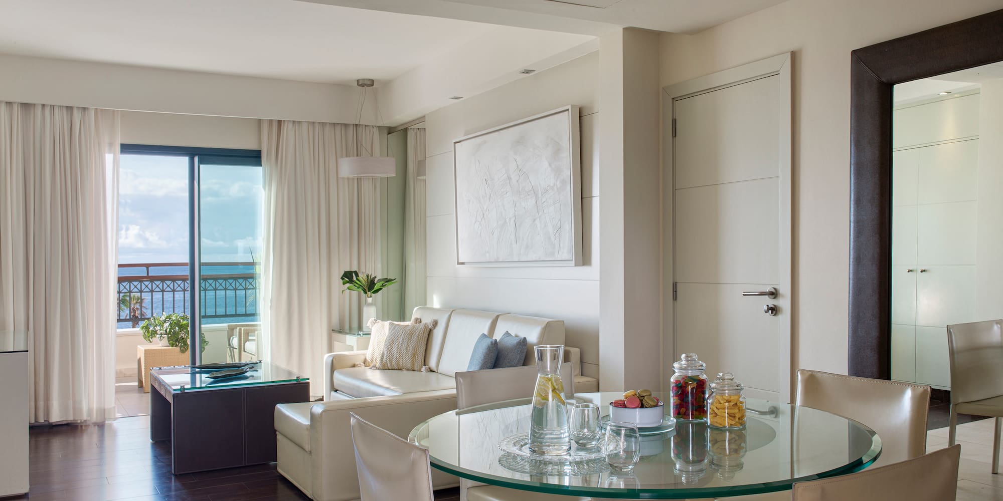 a room with a glass table and chairs