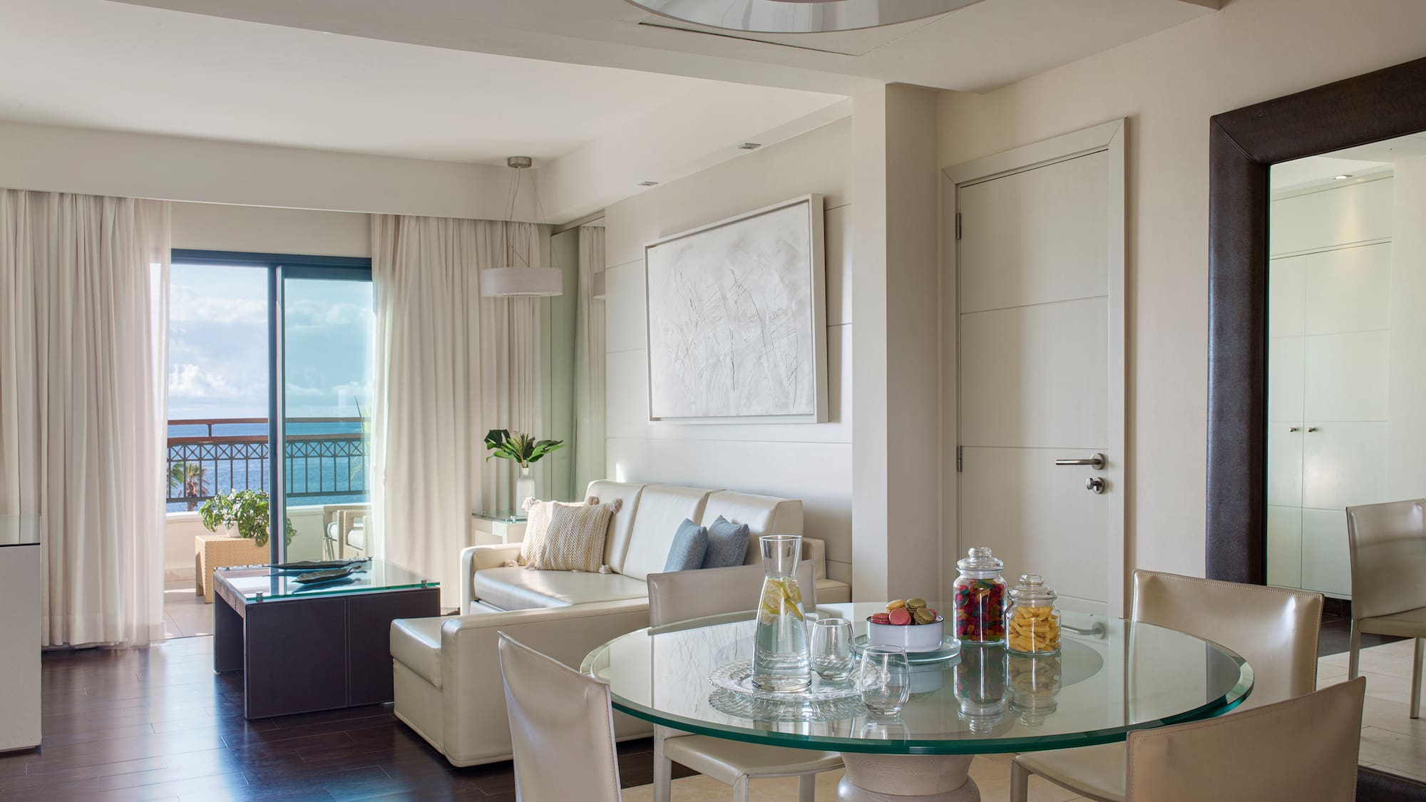 a room with a glass table and chairs