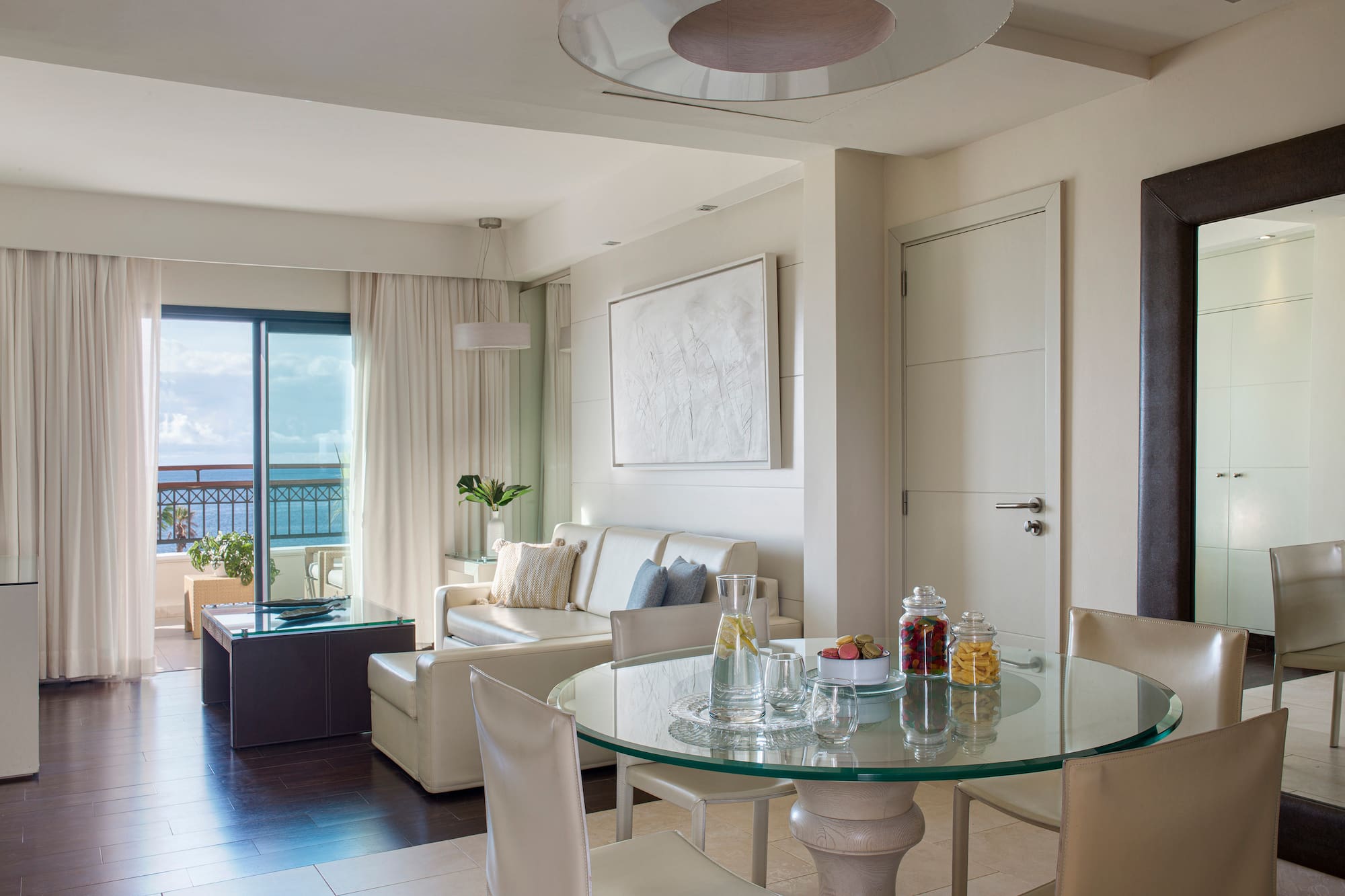 a room with a glass table and chairs