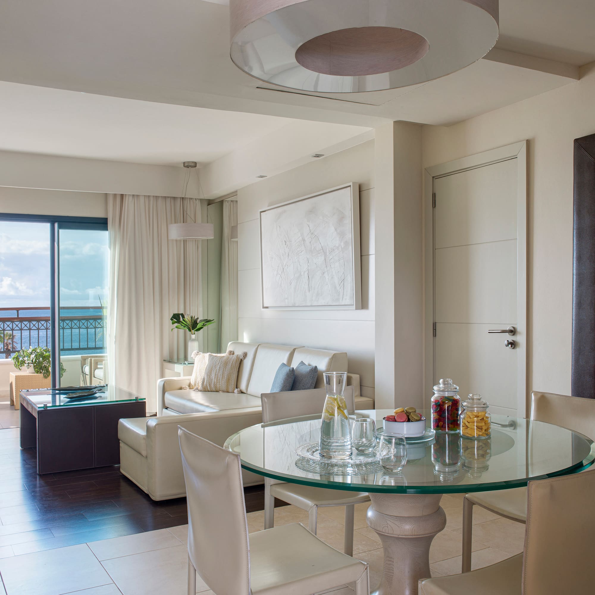 a room with a glass table and chairs