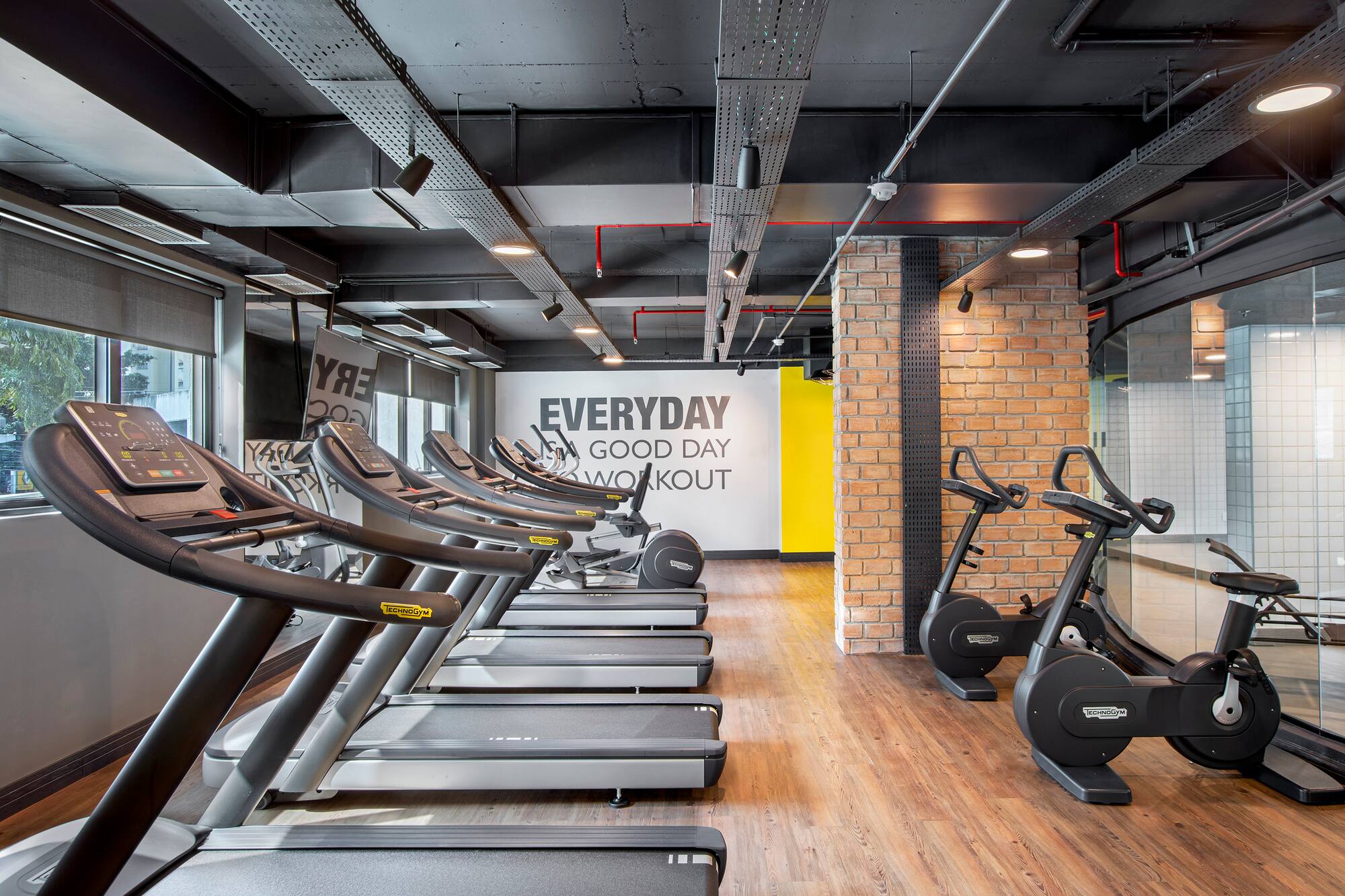 Modern gym with rows of treadmills, exercise bikes, and inspirational wall art.