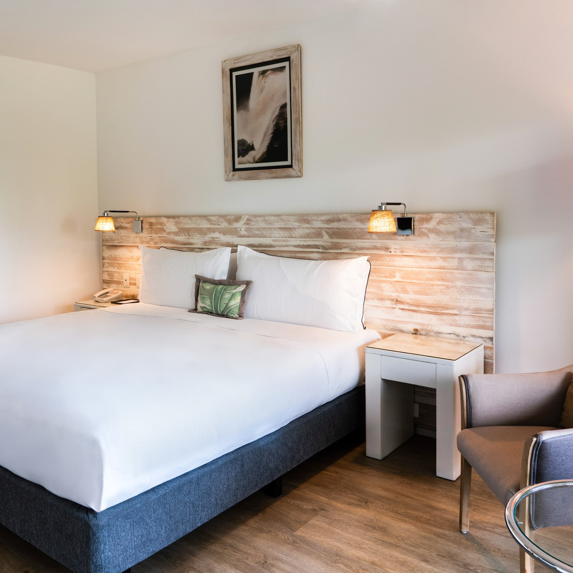 a bed with a wood headboard and a chair