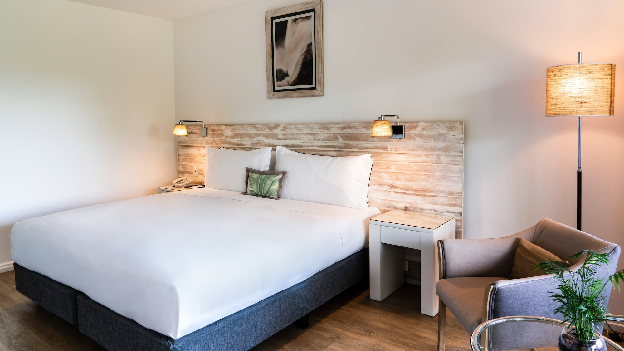 a bed with a wood headboard and a chair