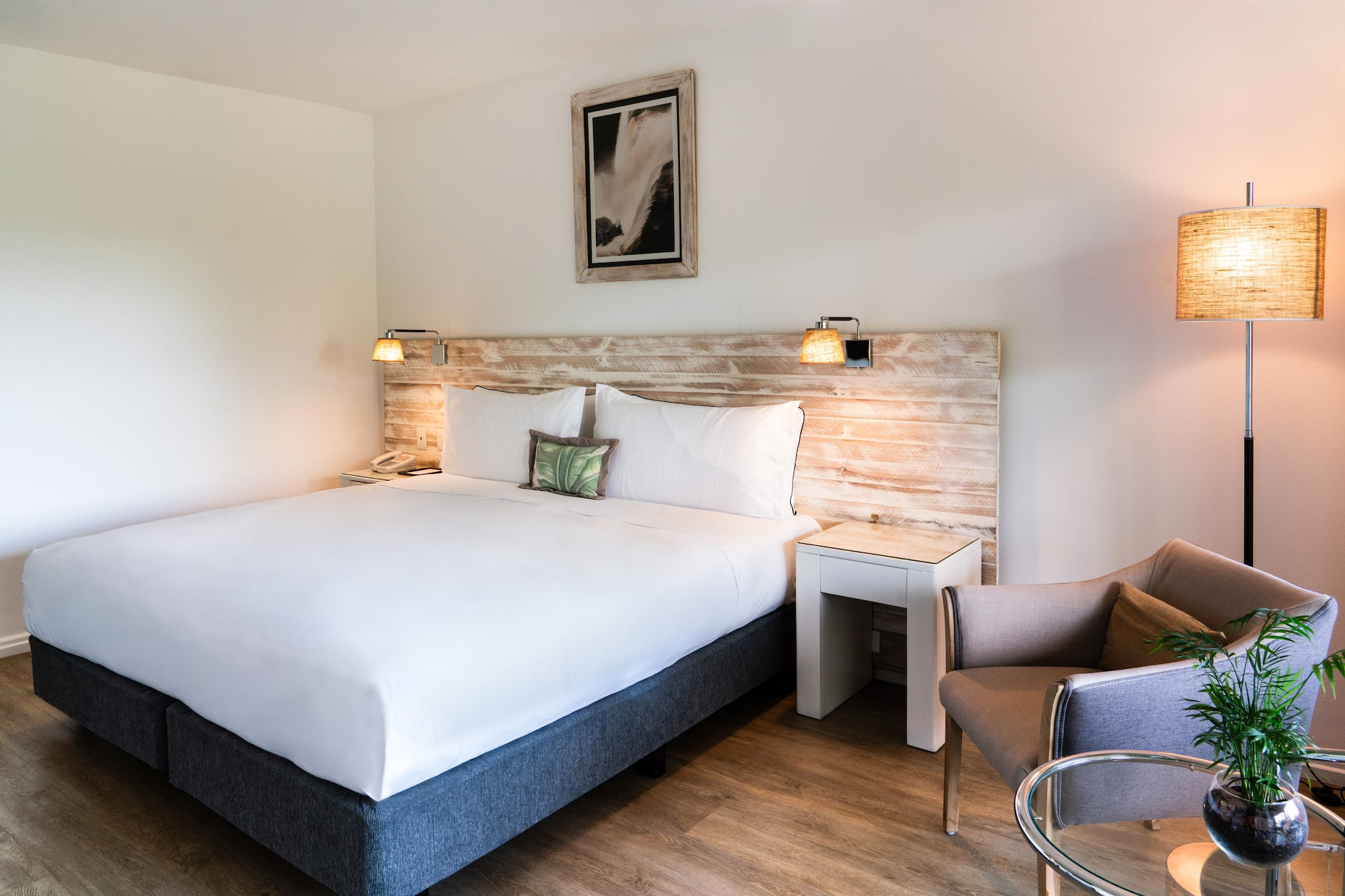 a bed with a wood headboard and a chair