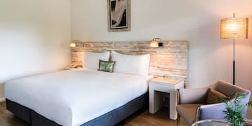 a bed with a wood headboard and a chair