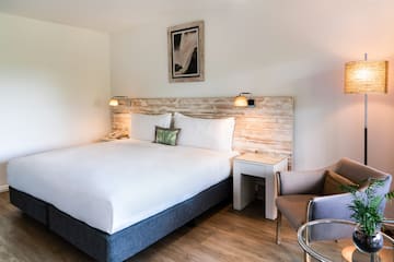 a bed with a wood headboard and a chair