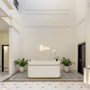 a white room with a bathtub and plants