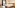 Bright hotel room with large white bed, wooden headboard, and scenic balcony.
