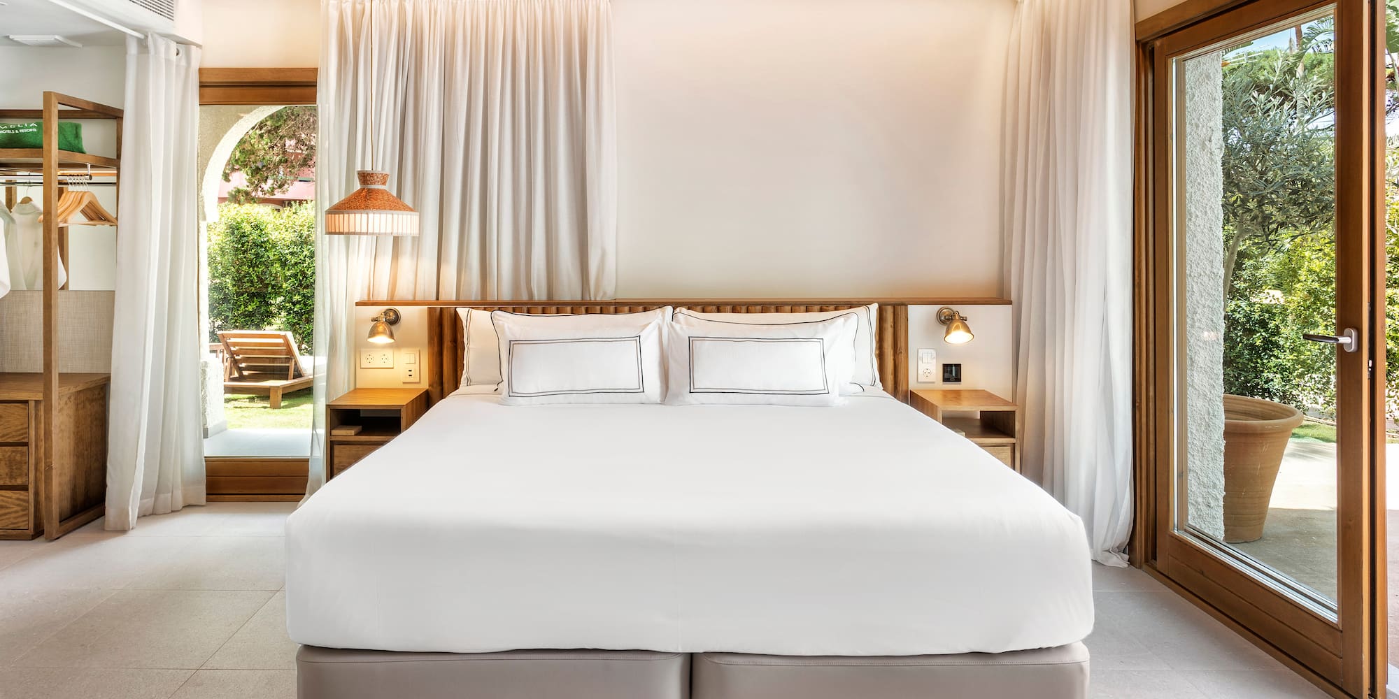 a bed with white sheets and lamps in a room with a wood ceiling