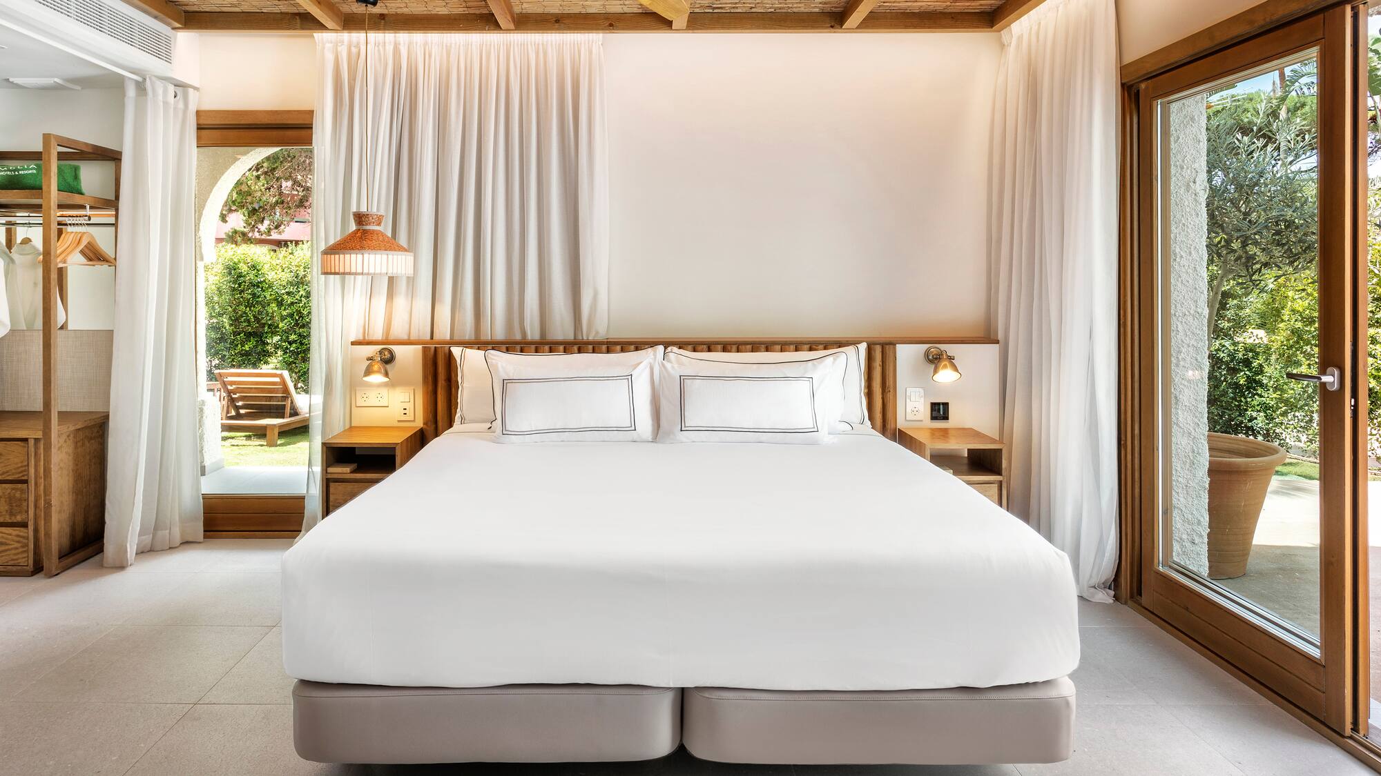 a bed with white sheets and lamps in a room with a wood ceiling