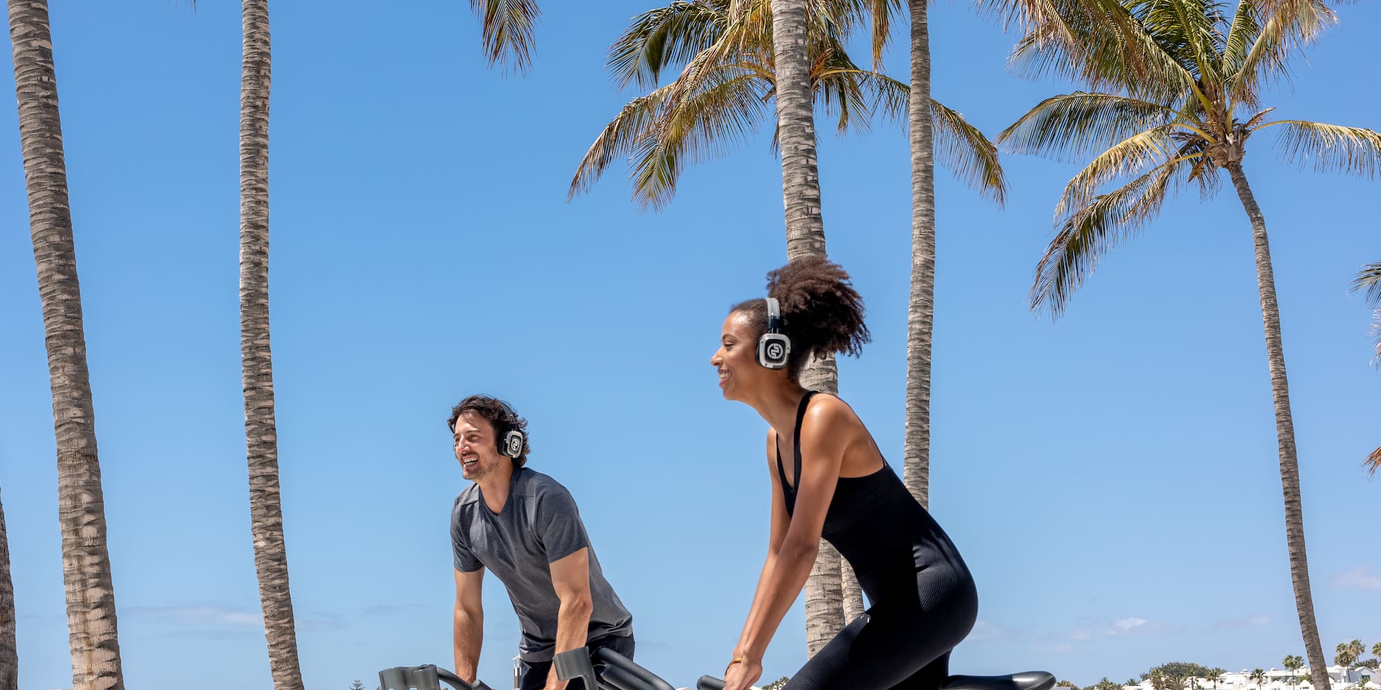 a man and woman riding bicycles on a beach