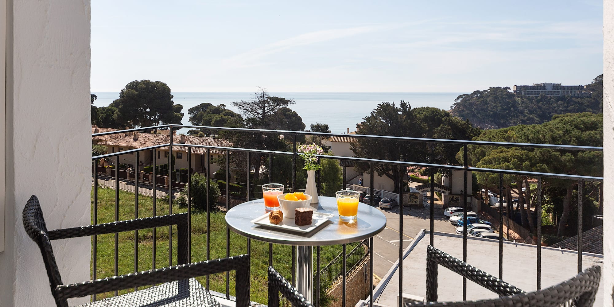 a table with food on it and chairs on a balcony overlooking a city