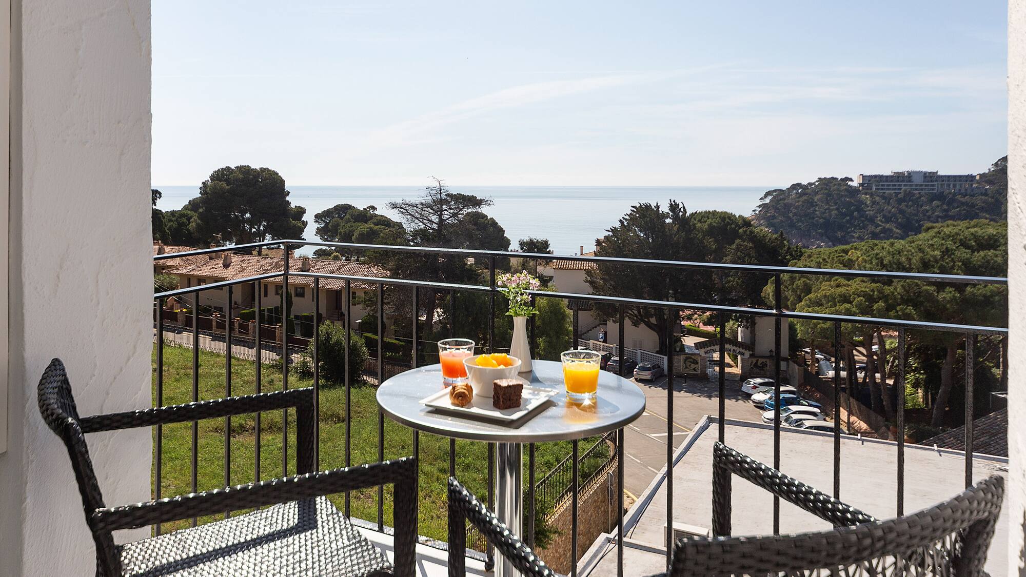 a table with food on it and chairs on a balcony overlooking a city
