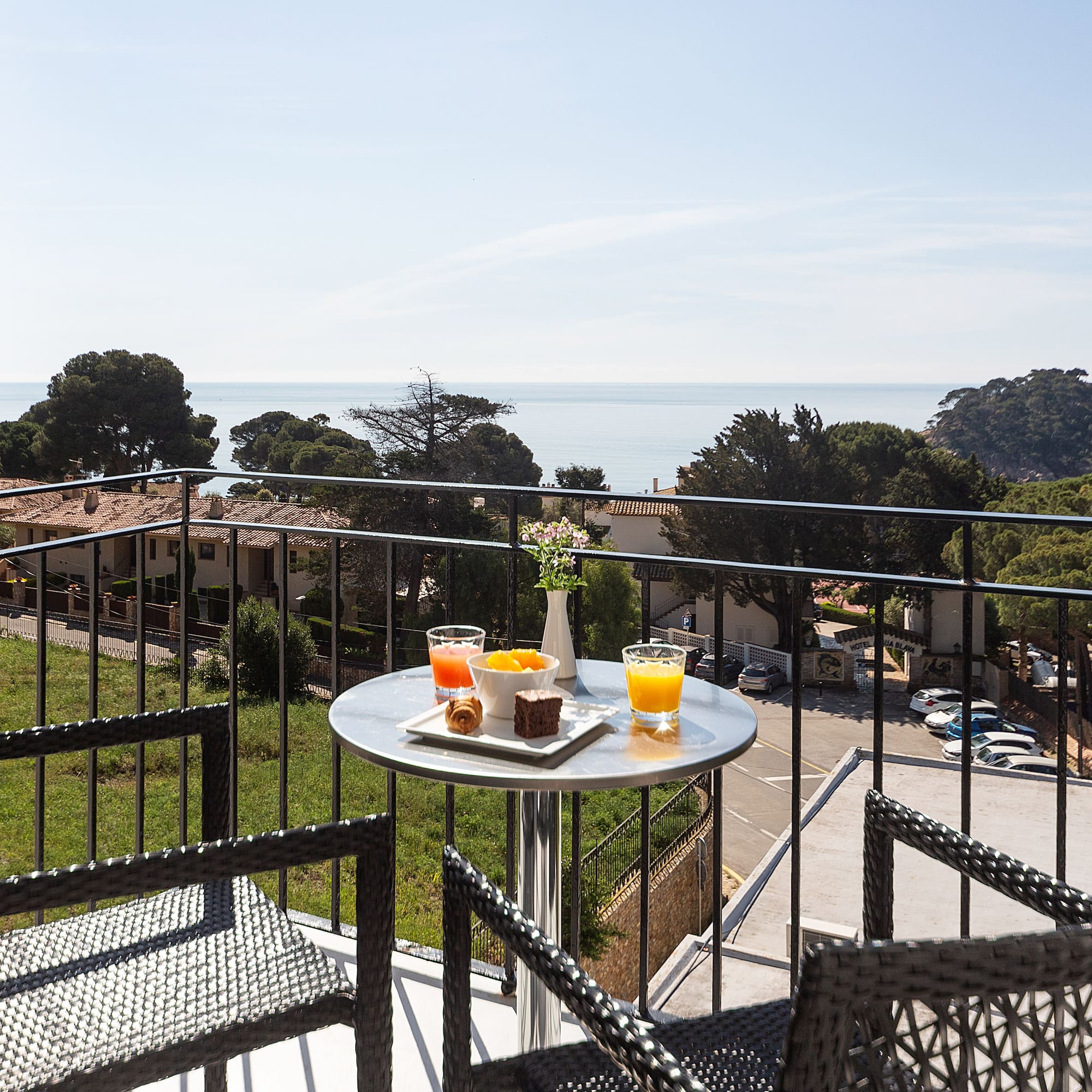 a table with food on it and chairs on a balcony overlooking a city