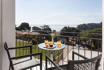 a table with food on it and chairs on a balcony overlooking a city