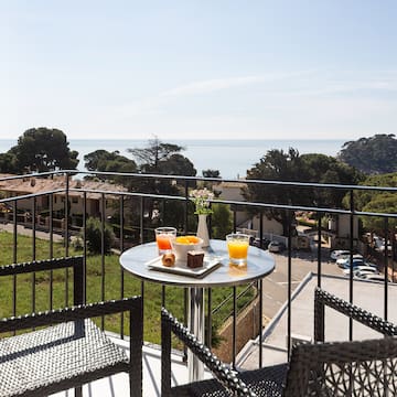 a table with food on it and chairs on a balcony overlooking a city