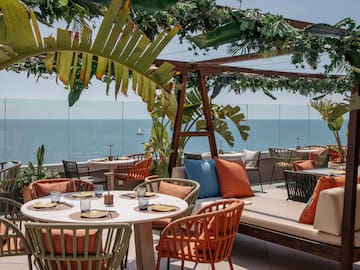 a table and chairs on a patio overlooking the ocean