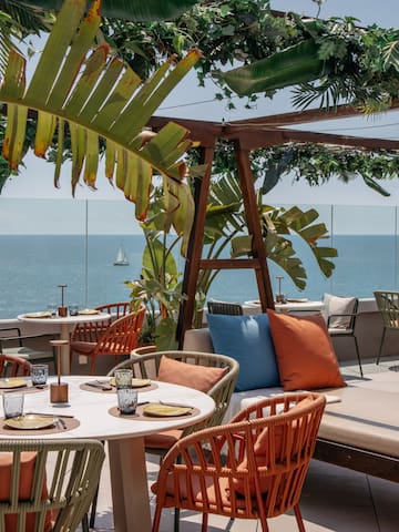 a table and chairs on a patio overlooking the ocean