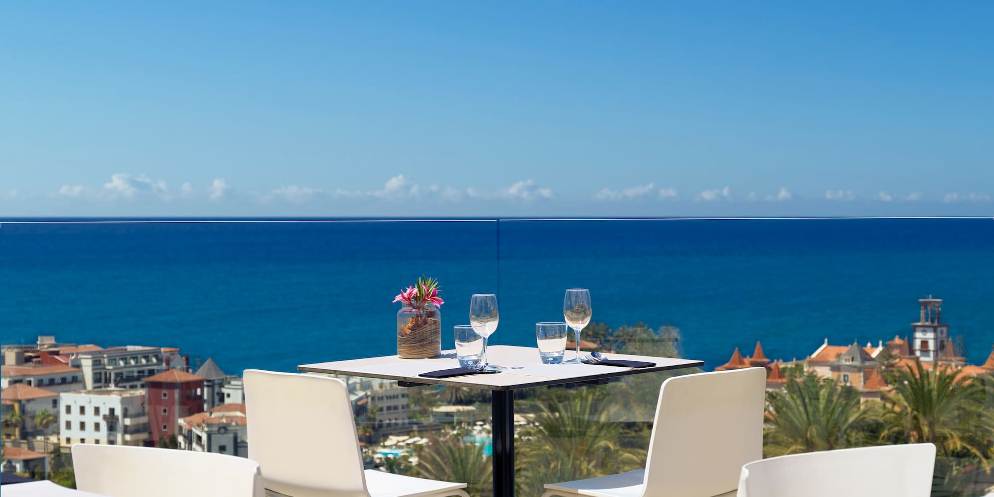 a table and chairs with a view of the ocean