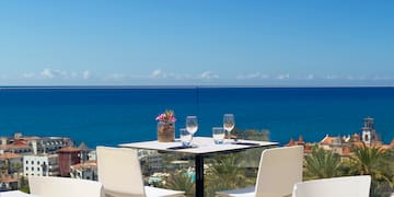 a table and chairs with a view of the ocean