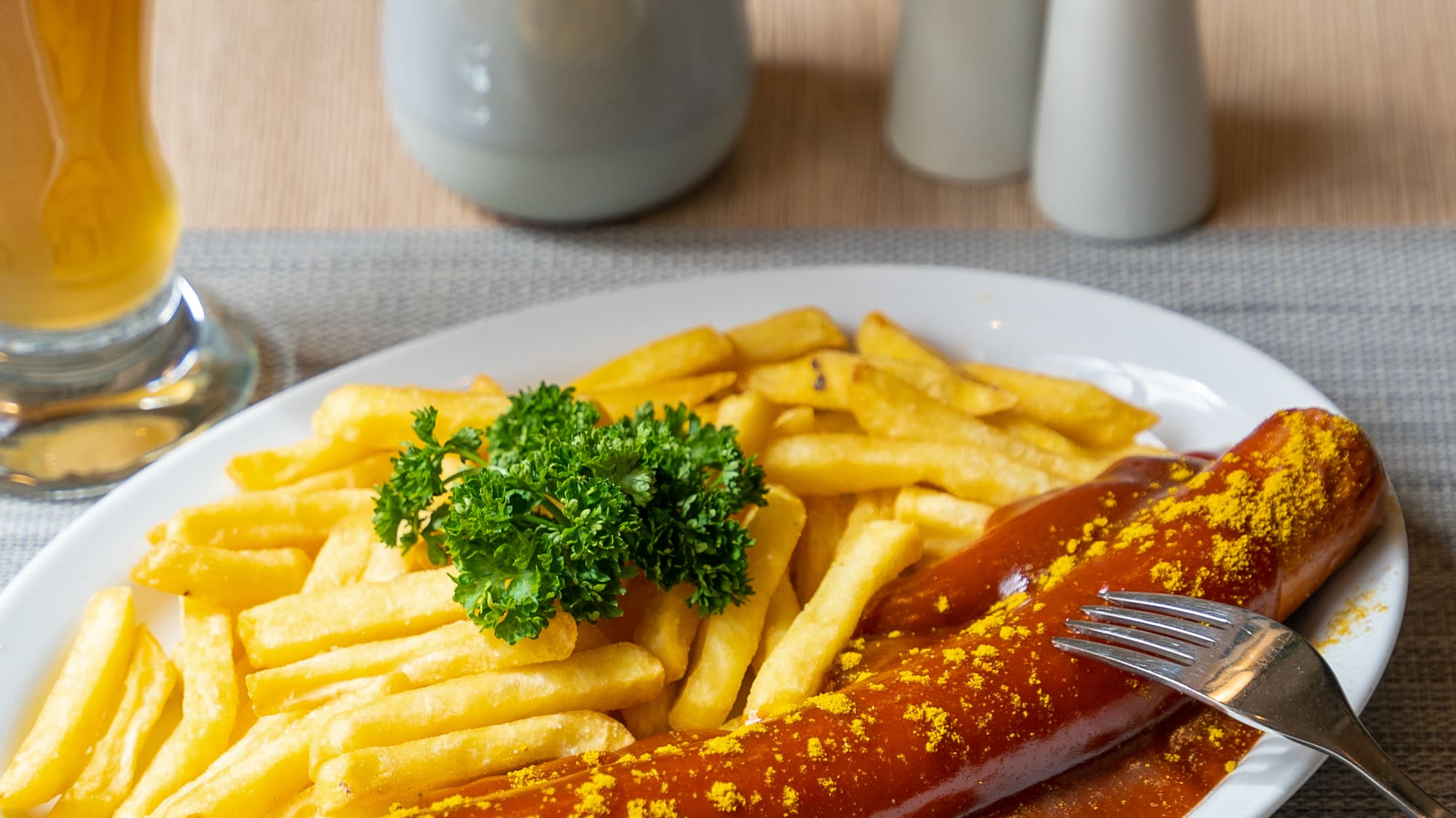 a plate of food with a fork and a glass of beer