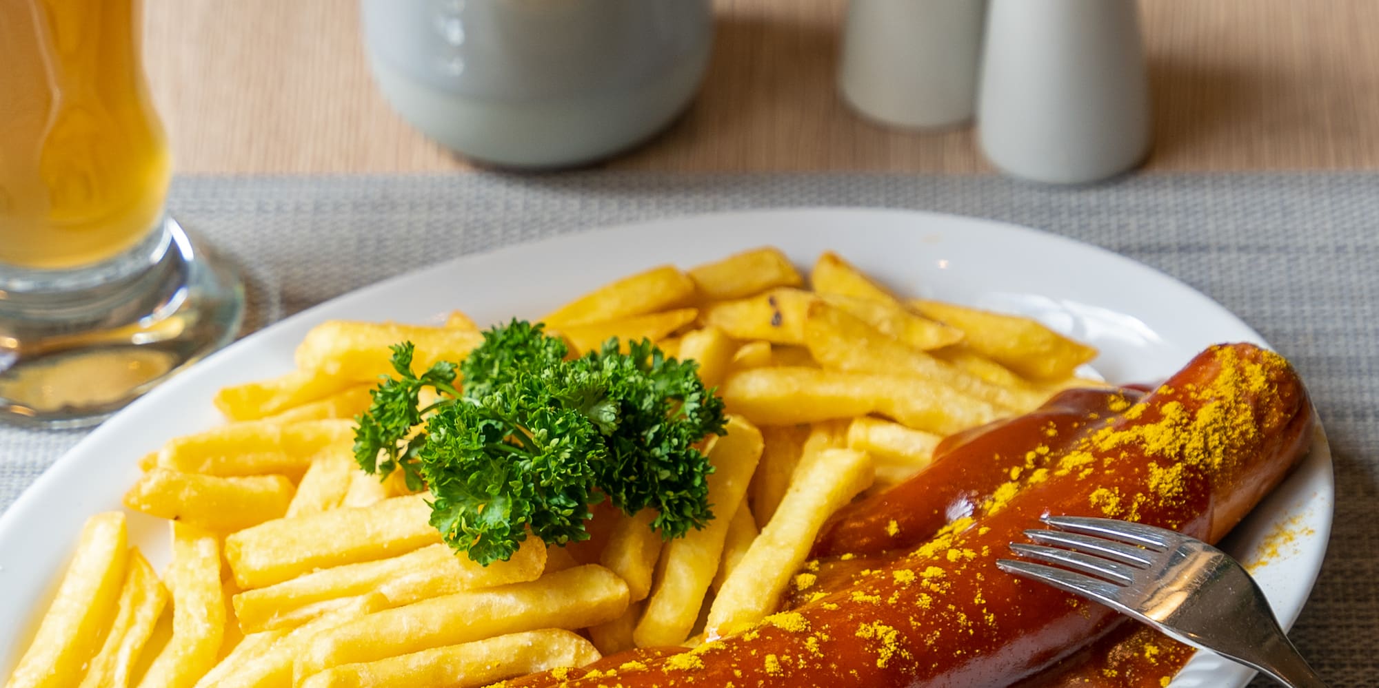 a plate of food with a fork and a glass of beer