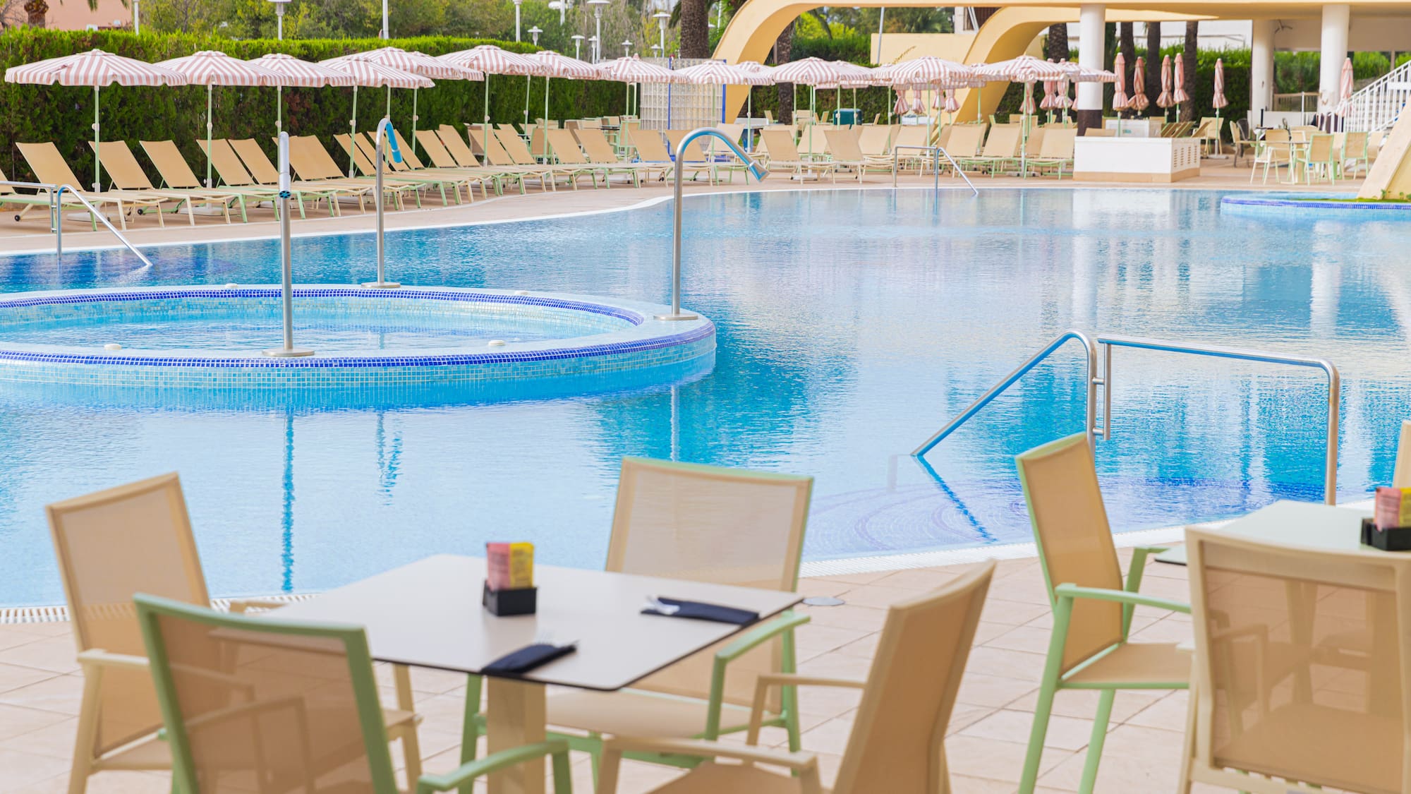 a pool with chairs and tables