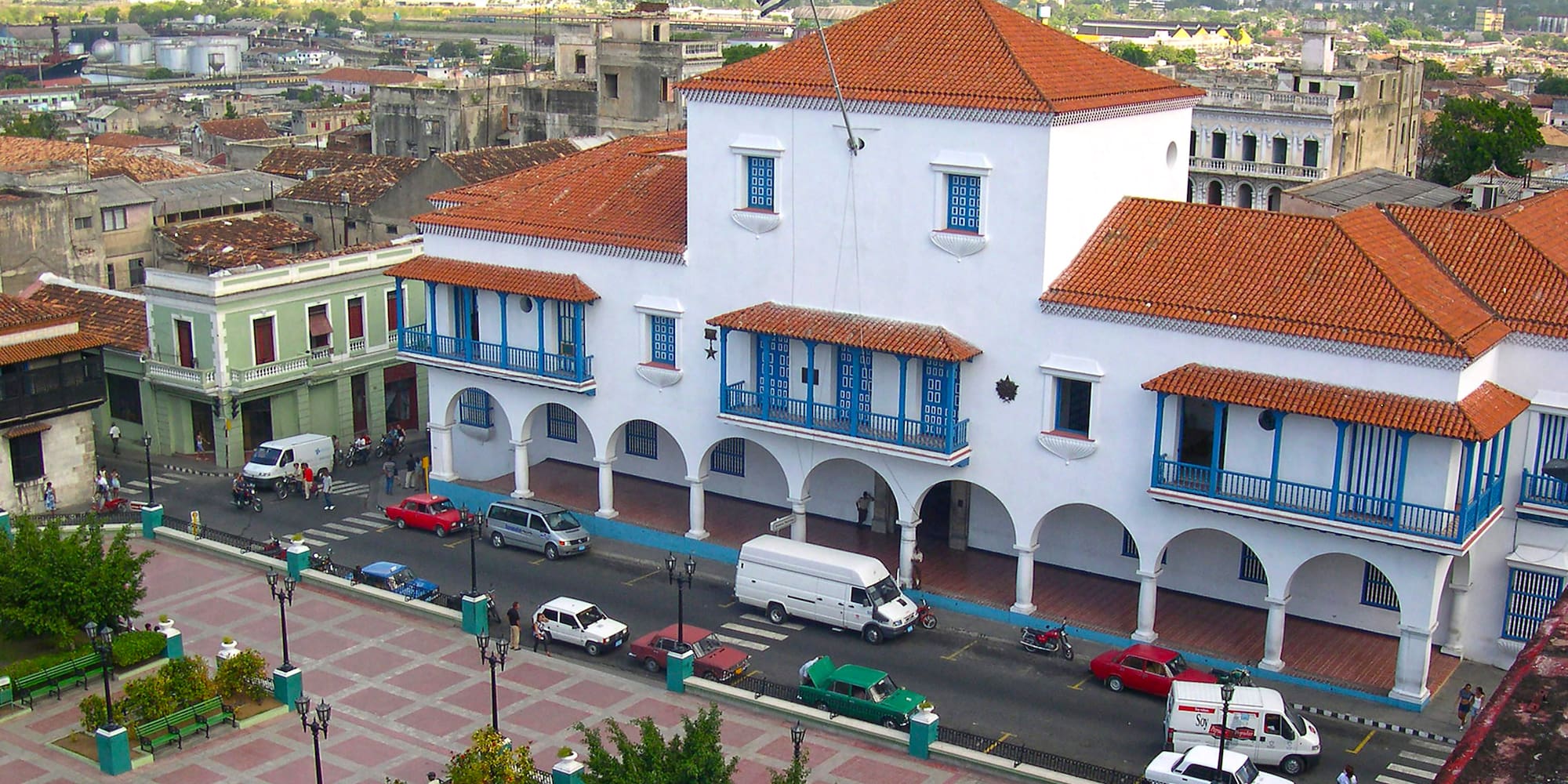 a white building with blue balconies and red roofs