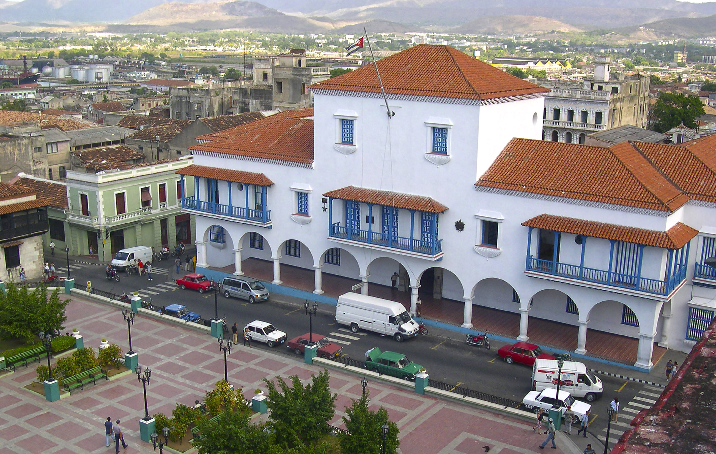 a white building with blue balconies and red roofs