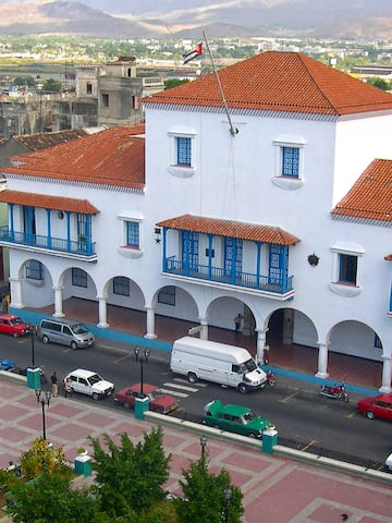 a white building with blue balconies and red roofs