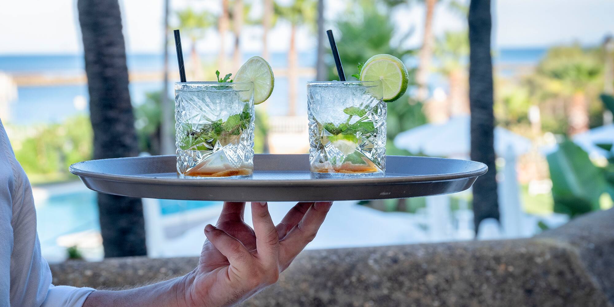 a person holding a tray with drinks on it