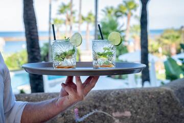 a person holding a tray with drinks on it