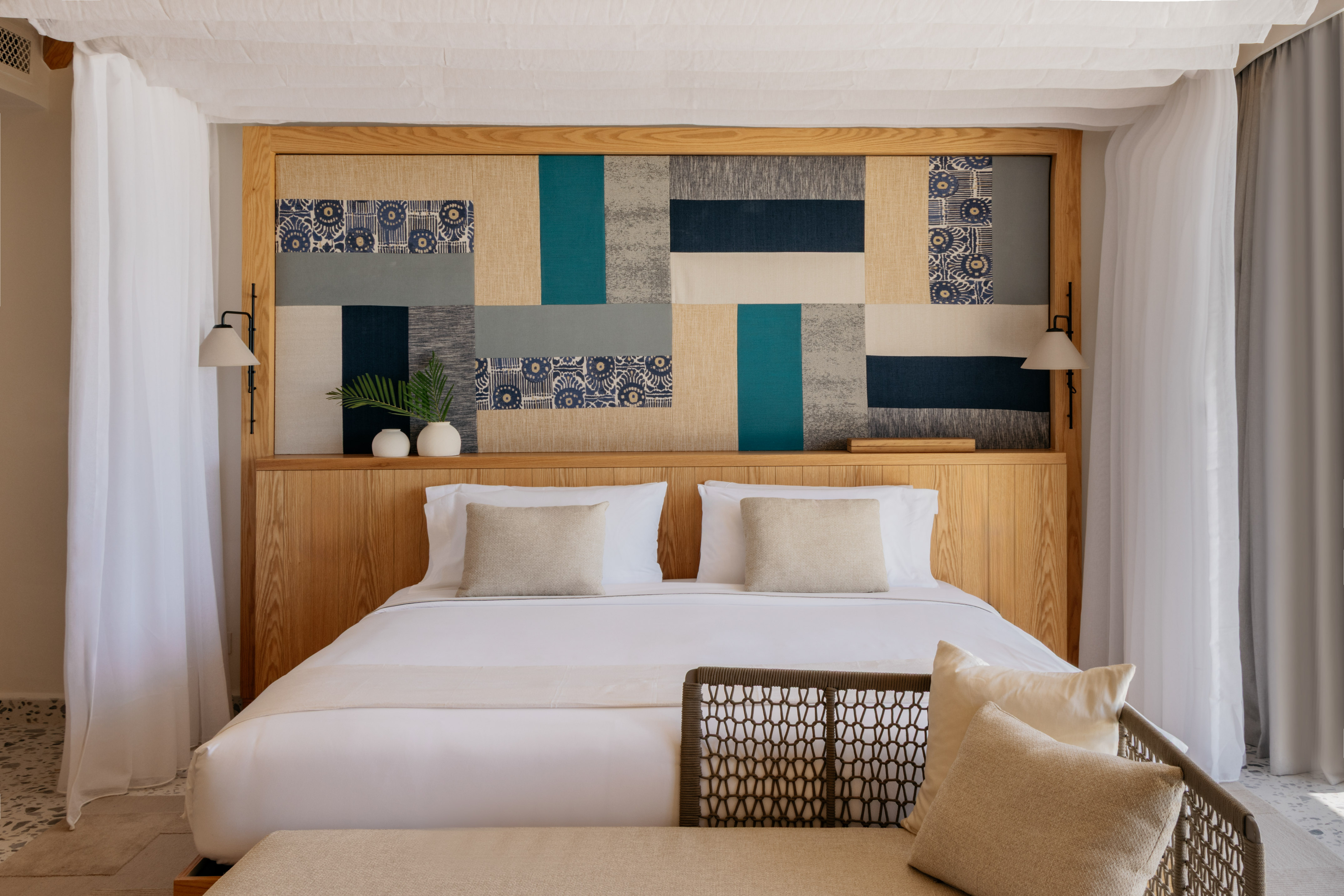 Modern luxury bedroom with patterned fabric headboard and crisp white bed.