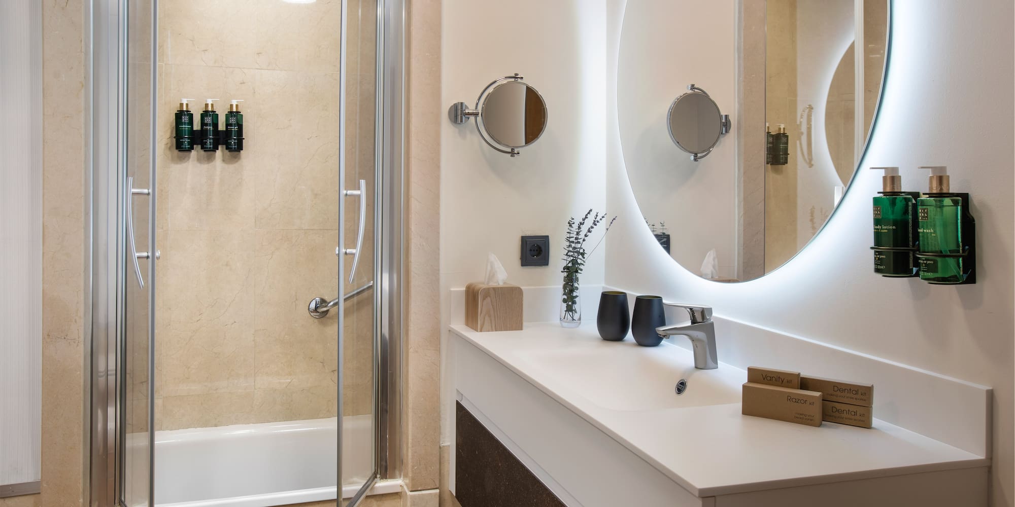 a bathroom with a round mirror and a shower