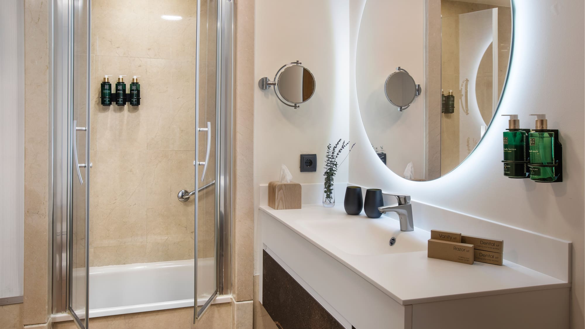 a bathroom with a round mirror and a shower