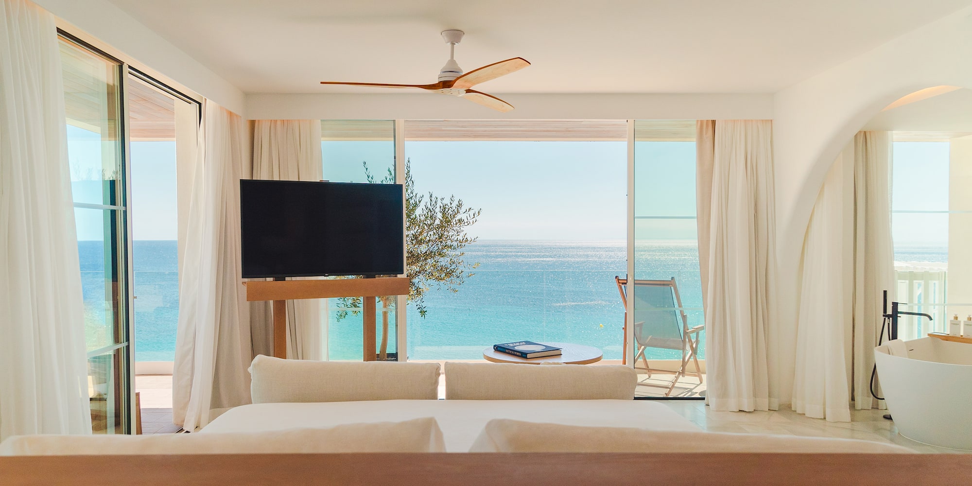 a room with a television and a view of the ocean