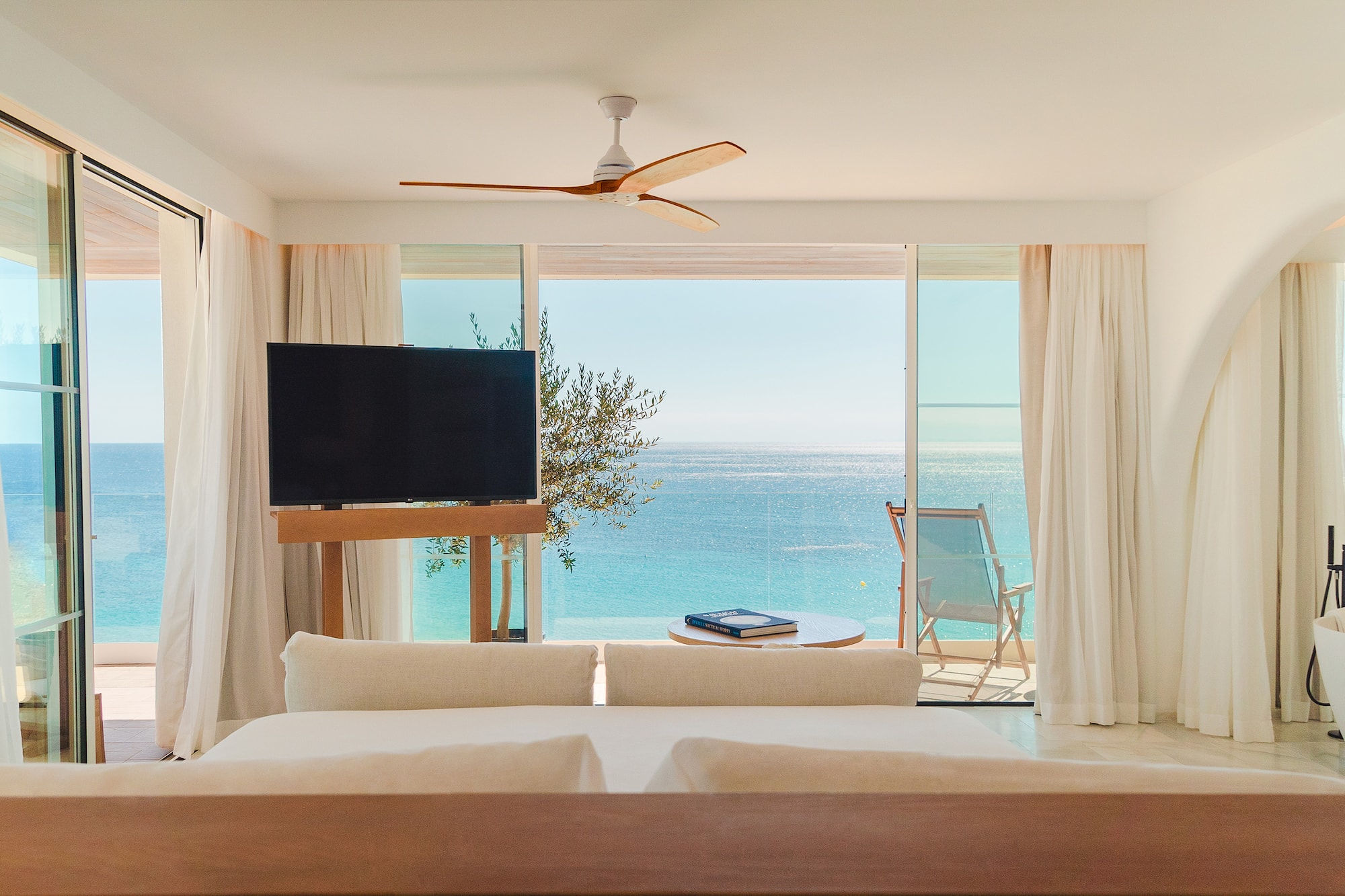 a room with a television and a view of the ocean