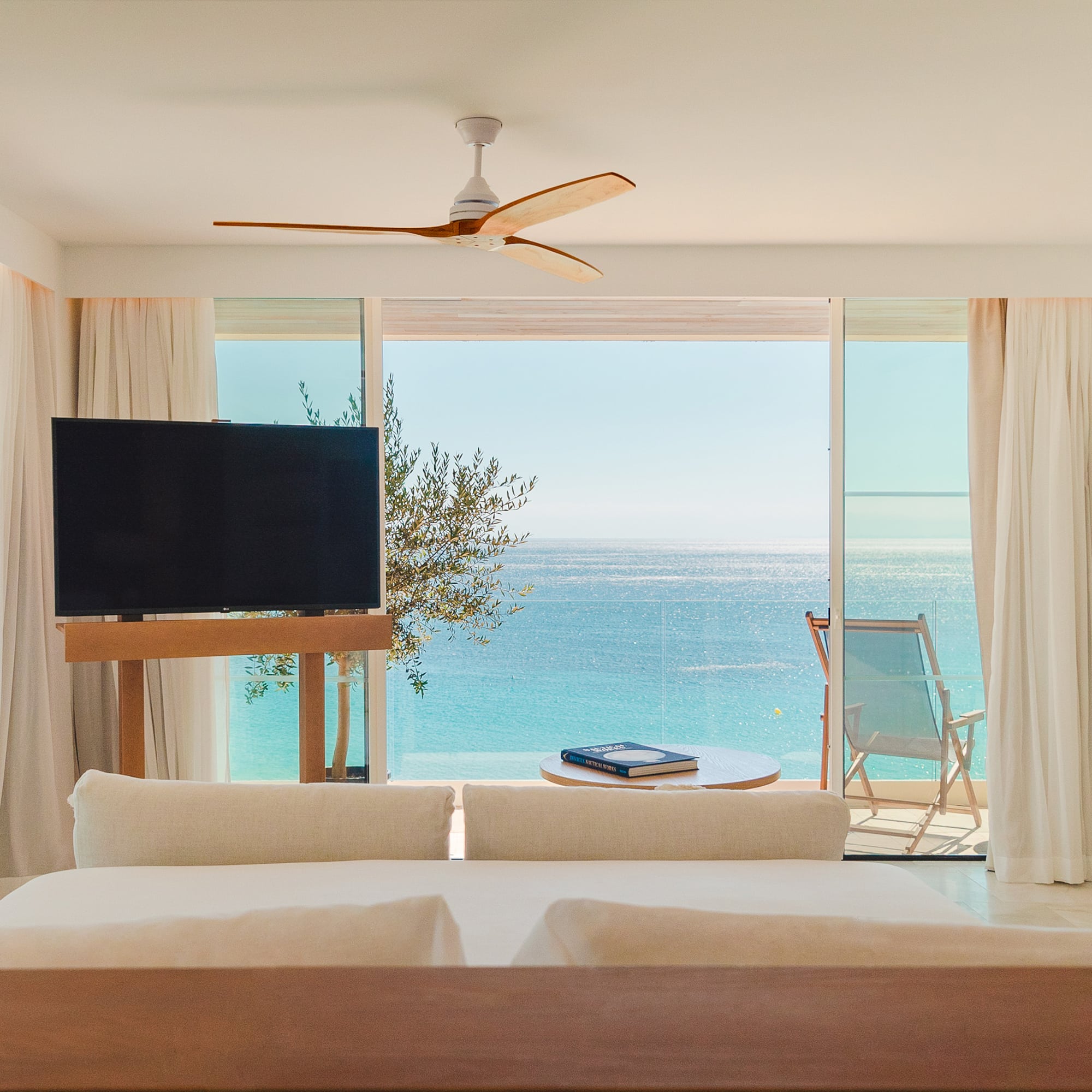 a room with a television and a view of the ocean