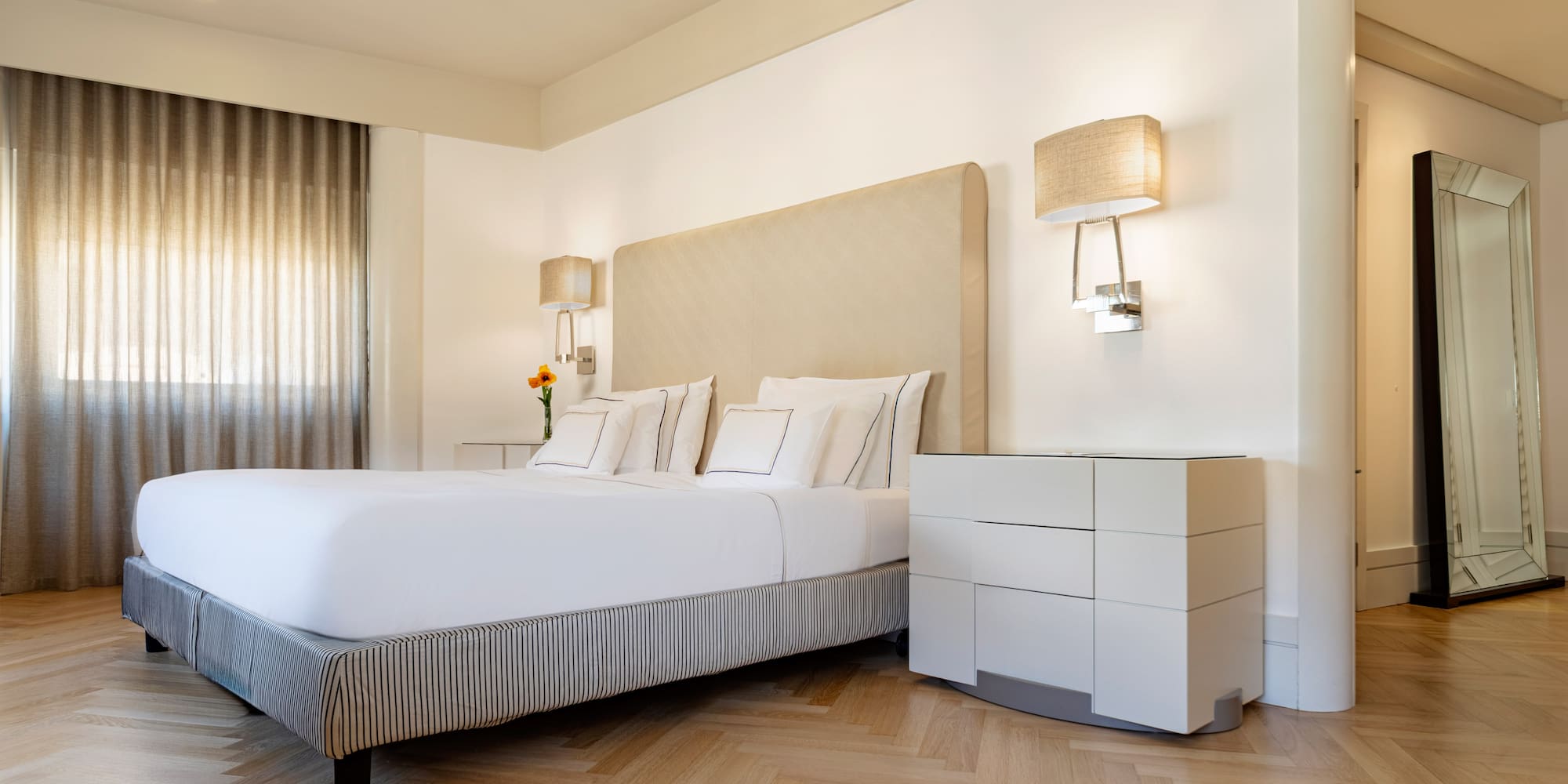 a bed with a headboard and lamps in a room