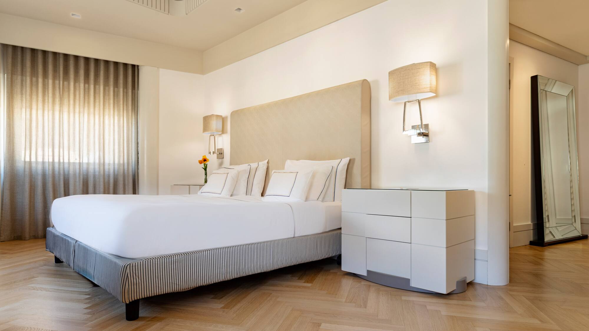 a bed with a headboard and lamps in a room
