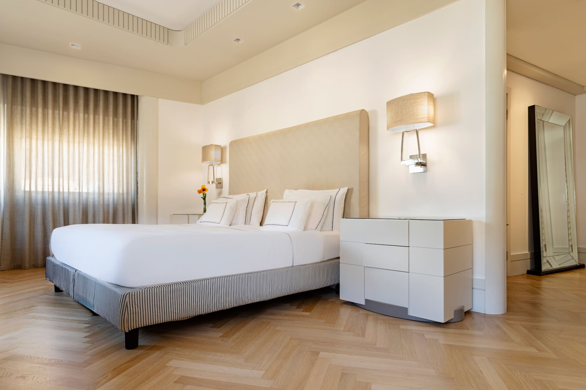 a bed with a headboard and lamps in a room