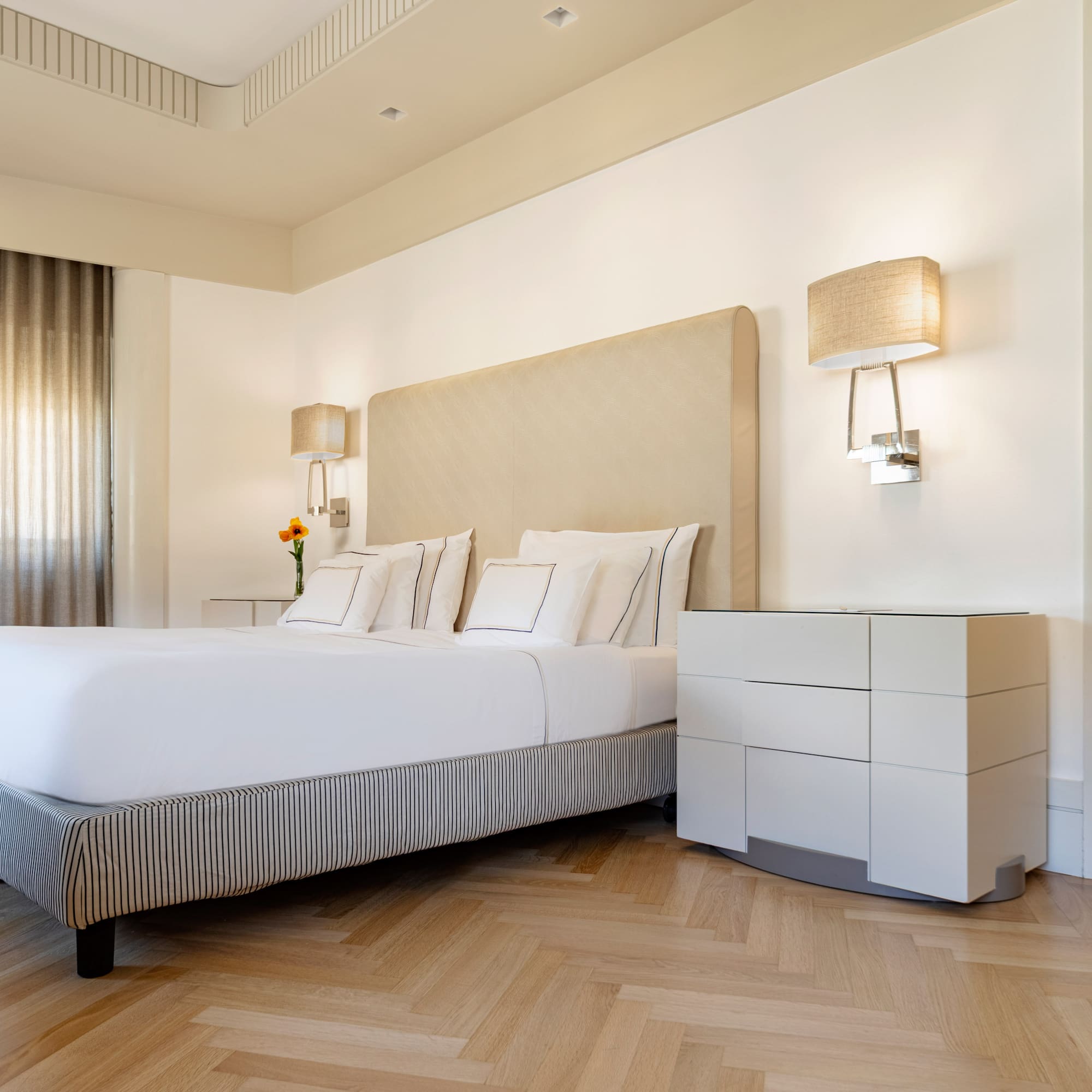 a bed with a headboard and lamps in a room